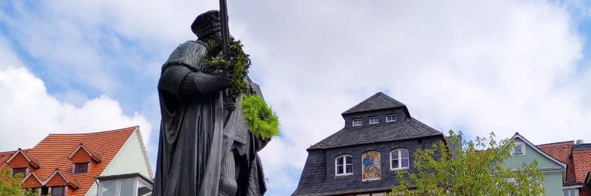 在Jena ist es Brauch，dass frischgebackene Doktor*innen einen Kranzüber das Schwert vom Hanfried（雕像von Johann Friedrich I.von Sachsen，dem Begründer der Universityät）auf dem Marktplatz werfen。（Das Foto zeigt einen Kranz，der in die Höhe geworfen wird und sein Ziel hoffentlich nicht verfehlt）。